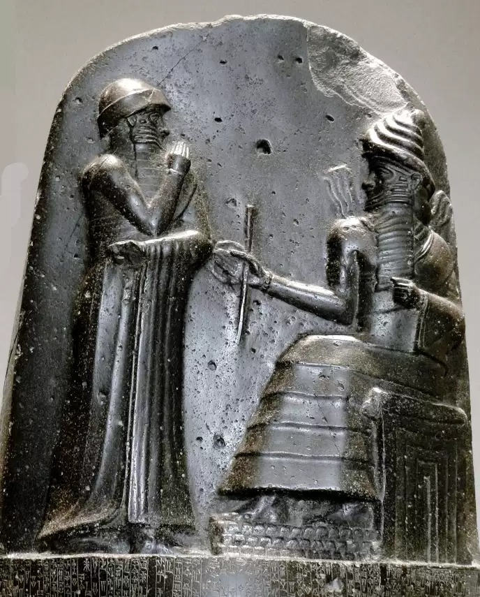 XVIIIe siècle avant notre ère, musée du Louvre. Dans le Proche-Orient ancien, ce sont traditionnellement les dieux (ici, Mardouk) qui remettent aux rois (ici, Hammourabi de Babylone) les insignes liées à leur fonction.
